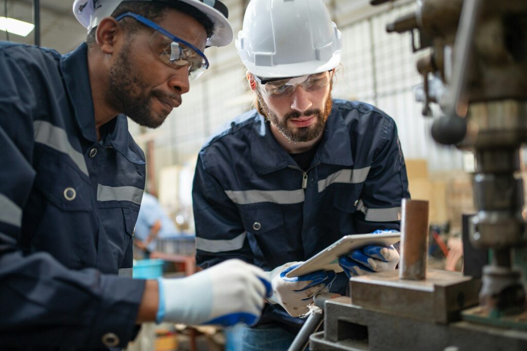 male engineers using tablet view drawing design of workpiece material on drilling machine at factory